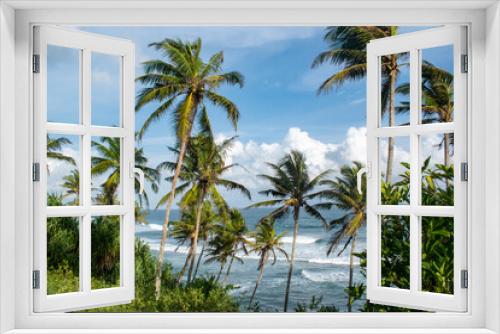 Fototapeta Naklejka Na Ścianę Okno 3D - Green tropical palm trees swaying in wind over blue ocean waves and blue sky and puffy clouds in Fiji