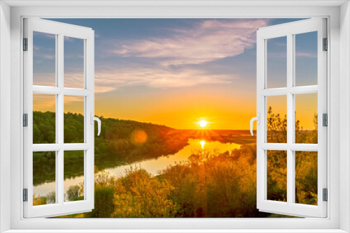 Fototapeta Naklejka Na Ścianę Okno 3D - Scenic view at beautiful spring sunset on a shiny river valley with green branches, trees, bushes, grass, golden sun, calm water ,deep blue cloudy sky and forest on a background, spring landscape