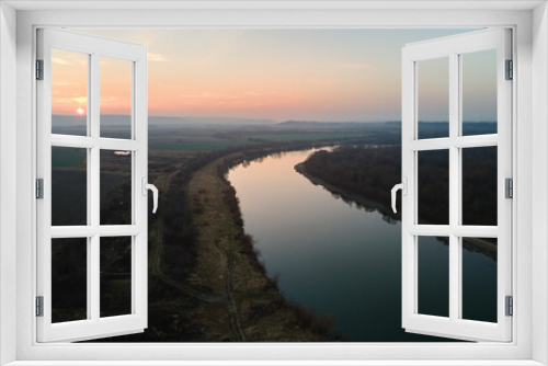 Fototapeta Naklejka Na Ścianę Okno 3D - Aerial view of wide river flowing quietly in rural countryside in autumn evening