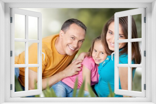 happy family with children having good time sitting on the grass in city park