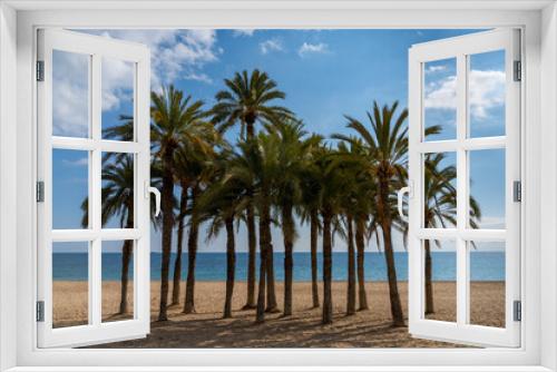 Fototapeta Naklejka Na Ścianę Okno 3D - group of lush green palm trees on a secluded golden sand beach with calm ocean behind