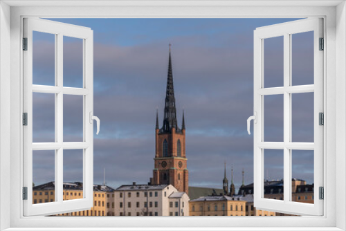 Fototapeta Naklejka Na Ścianę Okno 3D - Roofs of court house and the tower of the church Riddarholmskyrkan a sunny and snowy winter day in Stockholm 