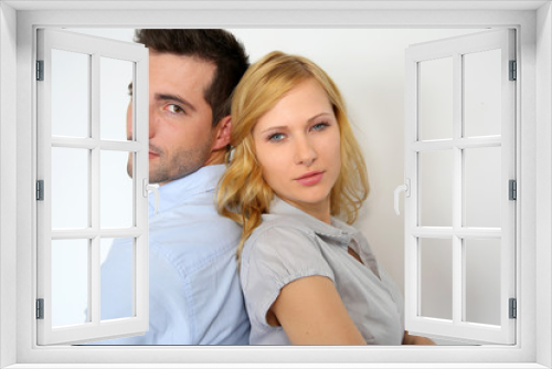 Couple standing back to back on white background