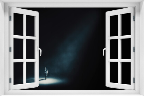 Fototapeta Naklejka Na Ścianę Okno 3D - Businesswoman walking under light in dark room