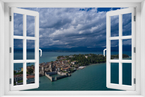 Fototapeta Naklejka Na Ścianę Okno 3D - Rocca Scaligera Castle in Sirmione.  Aerial view on Sirmione sul Garda. Italy, Lombardy.  Panoramic view at high altitude. Cumulus clouds over the island of Sirmione. Aerial photography with drone.