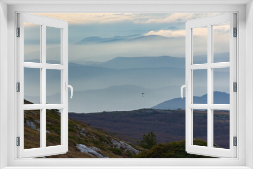 Fototapeta Naklejka Na Ścianę Okno 3D - Pastel sky blue view mountains. Gentle blurred natural atmospheric background. Fog low clouds paraglider in the distance. Fabulous light blue dawn hour. Calm landscape, copy space. Travel concept