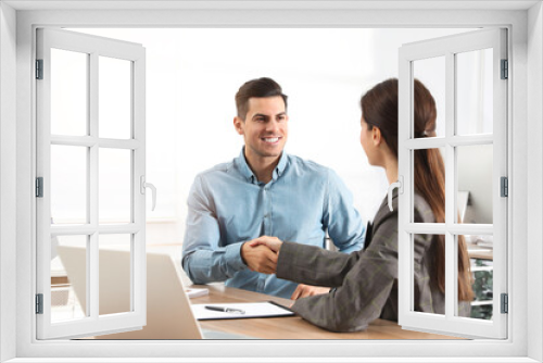 Employee shaking hands with intern in office