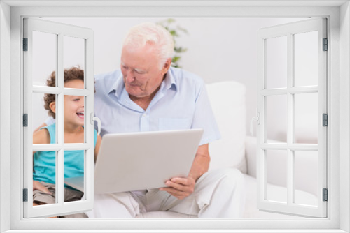 Grandfather and his grandson watching a laptop screen