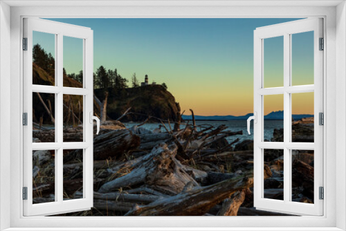 Fototapeta Naklejka Na Ścianę Okno 3D - Sunset in Cape Disappointment state park.dramatic sun setting in Cape Disappointment rocky cliffs and light house with massive drift wood logs on the bay area.