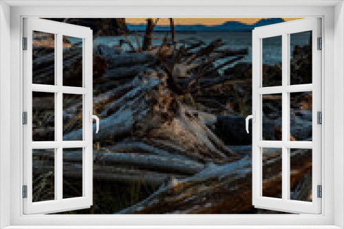 Fototapeta Naklejka Na Ścianę Okno 3D - Sunset in Cape Disappointment state park.dramatic sun setting in Cape Disappointment rocky cliffs and light house with massive drift wood logs on the bay area.