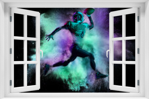 Fototapeta Naklejka Na Ścianę Okno 3D - Creaive collage. American football player in motion, catching ball isolated over colorful powder explosion on black background