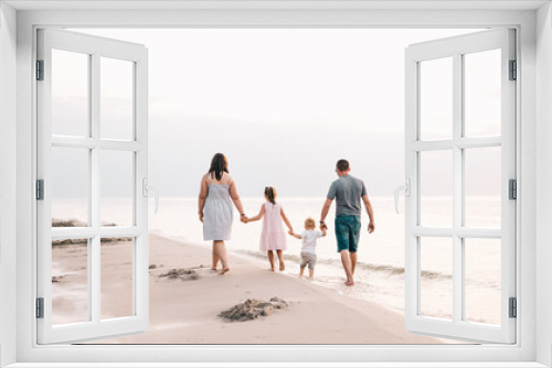 Fototapeta Naklejka Na Ścianę Okno 3D - Spacerująca brzegiem morza rodzina