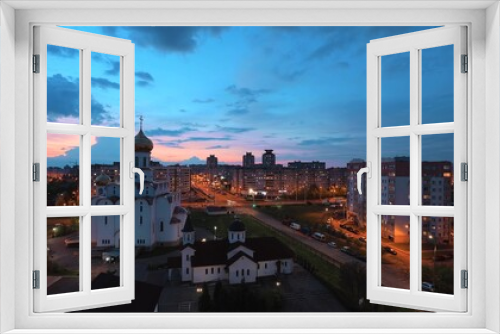 Fototapeta Naklejka Na Ścianę Okno 3D - Change Day To Night Transition Traffic On Street And Multi-storey Residential Houses. Cityscape Minsk Skyline With Russian Orthodox Church. 4K Cloudy Sky With Clouds In Motion Above Multi-storey