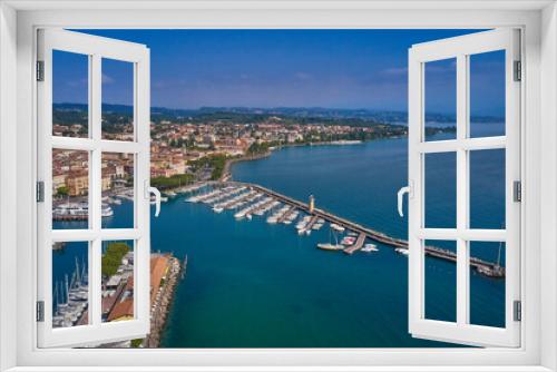 Fototapeta Naklejka Na Ścianę Okno 3D - Aerial panorama of the town of Desenzano del Garda on Lake Garda in Italy. Italian resorts on Lake Garda. Aerial view of Desenzano del Garda. Top view of the boat parking on the lake.