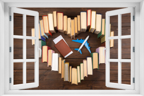 Fototapeta Naklejka Na Ścianę Okno 3D - Education abroad creative concept. Heart shape of books and airplane on the wooden desk. Love to travel