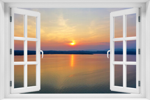Fototapeta Naklejka Na Ścianę Okno 3D - Sunrise over Lake Garda. Reflection of the morning sun in the water.