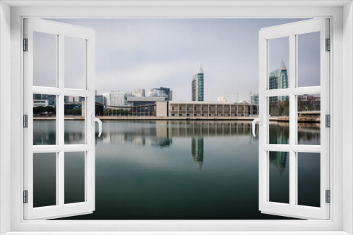 Fototapeta Naklejka Na Ścianę Okno 3D - Lisbon / Portugal - 12 28 2018: Panoramic view of modern buildings and skyscrapers reflecting in the calm water of a pond