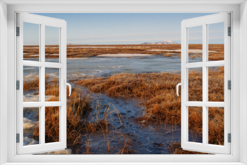 Fototapeta Naklejka Na Ścianę Okno 3D - Spring arctic landscape. View of the frozen swampy tundra in the floodplain of the river. Cold weather at the end of May in the polar region in the Arctic. Northern nature. Chukotka, Far North Russia.
