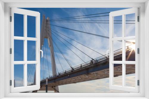 Fototapeta Naklejka Na Ścianę Okno 3D - Picturesque footbridge against a blue sky in light clouds