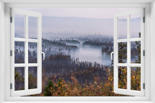 Fototapeta Naklejka Na Ścianę Okno 3D - Smoke settles in a valley following a destructive wildfire