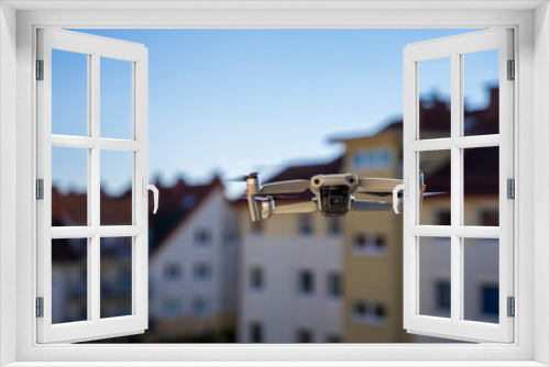 Fototapeta Naklejka Na Ścianę Okno 3D - Dron w mieście, dron leci wsród bloków mieszkalnych.