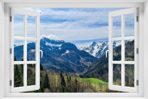 Fototapeta Naklejka Na Ścianę Okno 3D - Scenic view of snow capped mountain peaks of Karawanks near Sinacher Gupf in Carinthia, Austria. Mount Wertatscha and Hochstuhl (Stol) is visible in early spring. Hills in Rosental on sunny day. Hike