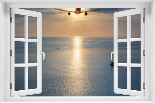 Fototapeta Naklejka Na Ścianę Okno 3D - Airplane flying over tropical sea atduring sunset,copy space for text.