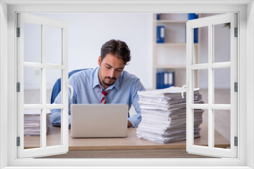 Young male employee and too much work in the office