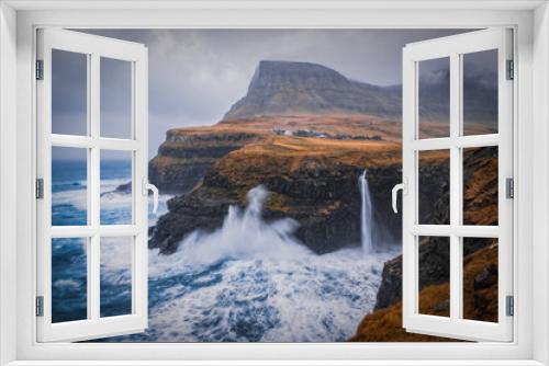Fototapeta Naklejka Na Ścianę Okno 3D - Dramatic view of Mulafossur waterfall with Gasadalur village on background. Vagar island, Faroe Islands, Denmark. November 2021.