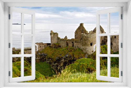 Ruins of Dunluce Castle, Antrim, Northern Ireland during sunny day with semi cloudy sky. Irish ancient castle near Wild Atlantic Way.