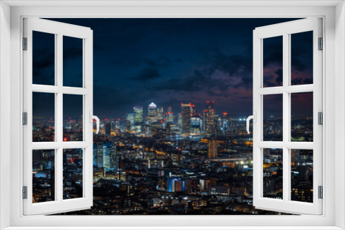 Fototapeta Naklejka Na Ścianę Okno 3D - Elevated view over the illuminated skyline of London during night time until the financial district Canary Wharf, England