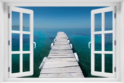 Fototapeta Naklejka Na Ścianę Okno 3D - White old wooden pier on the seashore on a beautiful sunny day. Corfu Greece