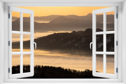 Fototapeta Naklejka Na Ścianę Okno 3D - 霞んだ遠くの山々と朝靄に覆われた湖。日本の北海道の美幌峠から見下ろす屈斜路湖の風景。