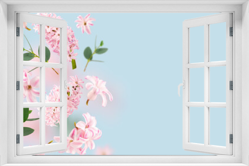 Fototapeta Naklejka Na Ścianę Okno 3D - Rose hyacinth flowers and green leaves flying in the air on spun sugar background. Levitation concept. Floating petals on a light blue. Postcard with wedding, women's day, mother's day. Copy spase