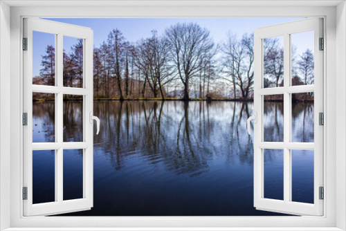Fototapeta Naklejka Na Ścianę Okno 3D - Baumspiegelung am tiefblauen ruhigen See