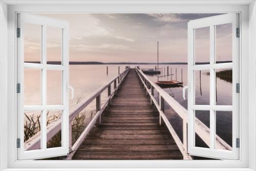 Fototapeta Naklejka Na Ścianę Okno 3D - Morgendliche Ruhe an einem See mit langem Bootssteg horizontal