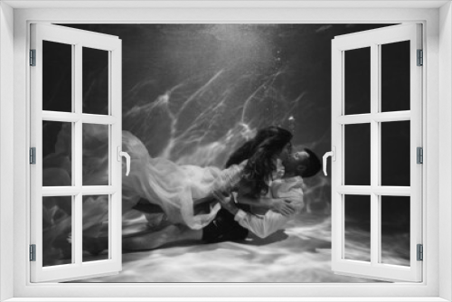 Fototapeta Naklejka Na Ścianę Okno 3D - A romantic couple kissing underwater in swimming pool wearing clothes