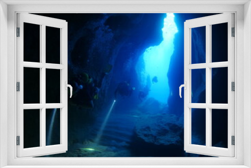 Fototapeta Naklejka Na Ścianę Okno 3D - cave diving underwater scuba divers exploring caves and having fun ocean scenery sun beams and rays background