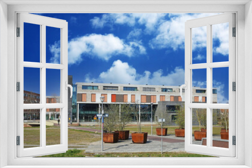 Fototapeta Naklejka Na Ścianę Okno 3D - Sittard, Netherlands - March 25. 2022: View on modern public buildings with library against blue sky with fluffy clouds
