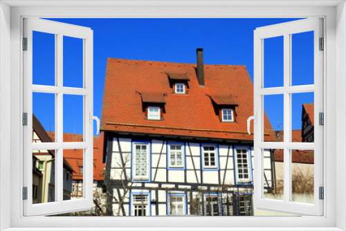 Fototapeta Naklejka Na Ścianę Okno 3D - schmuckes altes Fachwerkhaus mit rotem Dach unter blauem  Himmel im Zentrum von Nagold gelegen