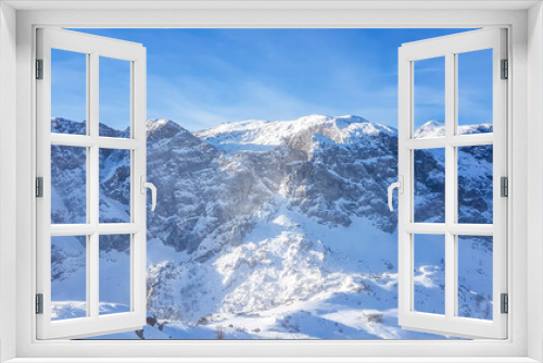 Fototapeta Naklejka Na Ścianę Okno 3D - A beautiful and serene landscape of mountains covered with snow. Thick snow covers the steep slopes. Clear weather. The mountain massive looks pretty dangerous. Possibility of an avalanche.