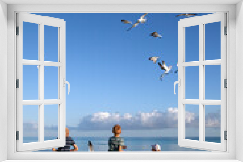 Fototapeta Naklejka Na Ścianę Okno 3D - children on the ocean feeding seagulls