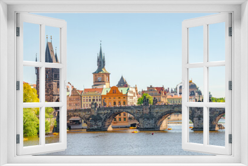 Fototapeta Naklejka Na Ścianę Okno 3D - View over magnificent Vltava river with tour boats, tourists and famous Charles Bridge and walking embarkment in historical downtown of Prague, Czech Republic at blue sunset summer sky.
