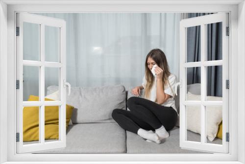 Depressed young woman covering face by hands, crying alone at home, upset girl sitting on sofa, feeling unhappy after quarrel or breakup, despair and lonely, psychological problem concept