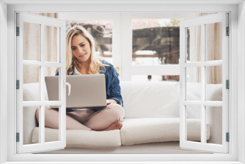 Its her favourite spot to browse. Shot of a young couple browsing on a laptop at home.