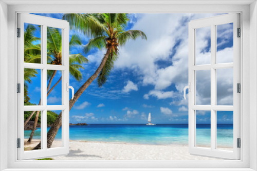 Fototapeta Naklejka Na Ścianę Okno 3D - Sunny beach with Coco palms and a sailing boat in the turquoise sea in Paradise island.	