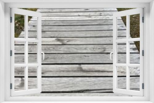 Fototapeta Naklejka Na Ścianę Okno 3D - a path of weathered gray wooden planks across a meadow through nature 