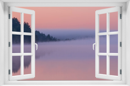 Fototapeta Naklejka Na Ścianę Okno 3D - Dawn over the foggy lake. Beautiful dreamy view. Pink sky just before the sunrise and fog over water and trees with reflections on river bank.