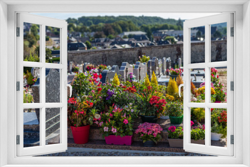 Fototapeta Naklejka Na Ścianę Okno 3D - Multicolored flowered graves in a cemetery on a sunny day.