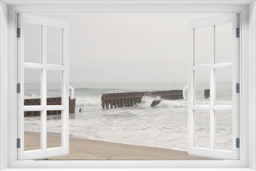Fototapeta Naklejka Na Ścianę Okno 3D - Ocean Waves Breaking Upon Wooden Sea Wall in Daylight